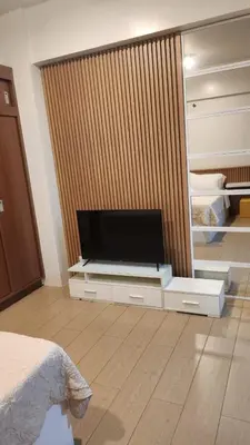 a living room with a flat screen tv on a dresser at Your Home Suite at 150 Newport Boulevard Condo near NAIA T3 in Manila