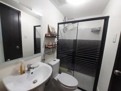 a bathroom with a shower and a toilet and a sink at Kasara Urban Resort premium studio staycation by Rain in Manila
