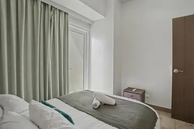 a bedroom with a bed with a towel on it at Lovely & Spacious 2BR Home near Solaire & Okada in Manila