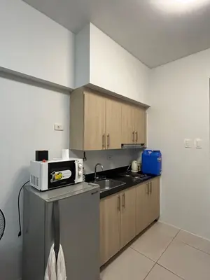 a kitchen with a sink and a microwave on a counter at CG Staycation Hub in Manila