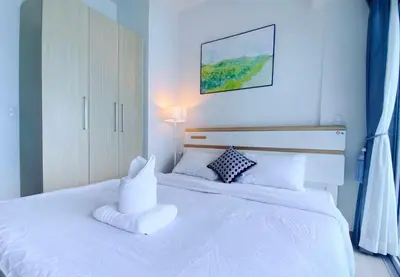a bedroom with a white bed with a pillow on it at 120 Sqm 3Bedrooms Facing Manila Bay Sunset, Airports, Okada, Solaire, MOA, free parking in Manila