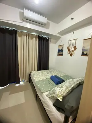 a small bedroom with a bed and a window at Stern Staycation Moa in Manila