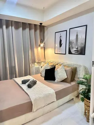 a bedroom with a large bed in a room at Staycation Condotels RD in Manila