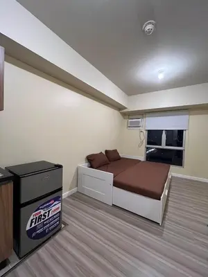 a small bedroom with a bed and a television at Staycation Condotels RD in Manila