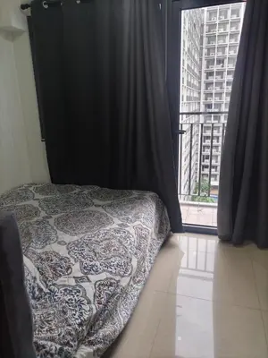 a bedroom with a bed and a large window at Metro Nest Inn in Manila