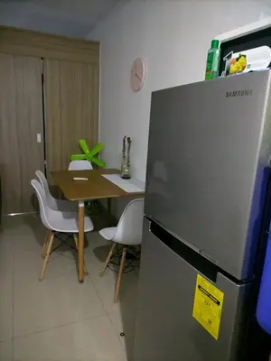 a kitchen with a table and a refrigerator at Metro Nest Inn in Manila