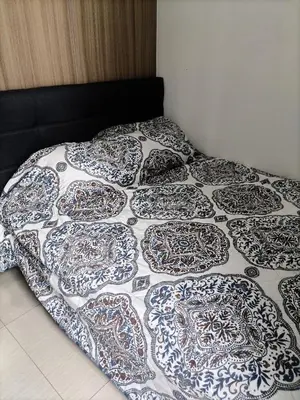a bed with a black and white comforter on it at Metro Nest Inn in Manila