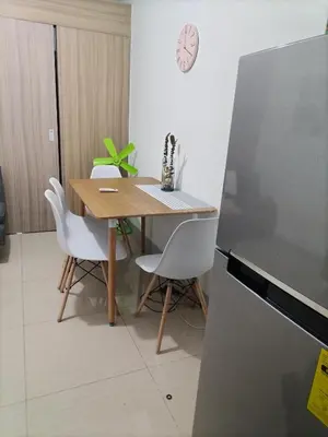 a kitchen with a wooden table and white chairs at Metro Nest Inn in Manila