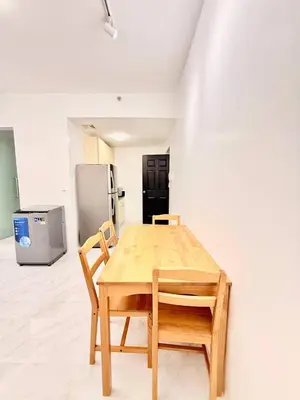 a wooden table with two chairs and a refrigerator at Malate Bayview Mansion City View and Seaview in Manila