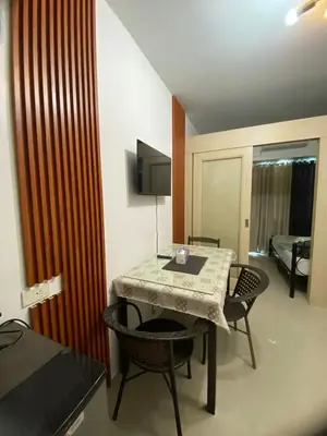 a room with a table and chairs and a bed at Sea Residences Staycation Moa ,Stern Homes in Manila