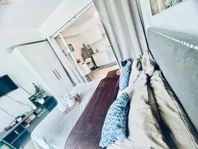 a bedroom with a bed and a mirror at Cozy Condos at Azure Urban Resort in Manila