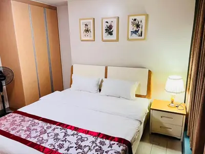 a bedroom with a bed and a table with a lamp at Easyworld One Uptown Residence BGC in Manila