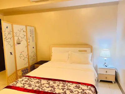 a bedroom with a bed and a table with a lamp at Easyworld One Uptown Residence BGC in Manila