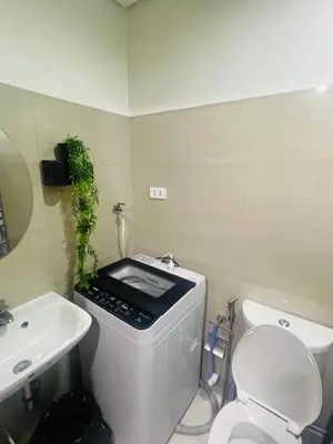 a bathroom with a white toilet and a sink at Shore2 Moa ph stay in Manila