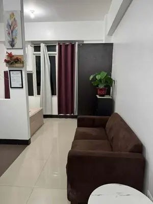 a living room with a brown couch in a room at Stamford Executive Residence a2 shortwalk Venice Canal mall in Manila