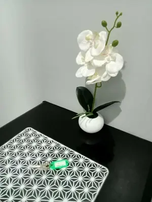 a black table with a white vase with white flowers at Stamford Executive Residence a2 shortwalk Venice Canal mall in Manila