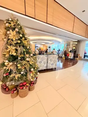a christmas tree in a hotel lobby with people at Shell Residences Prime By Paul in Manila