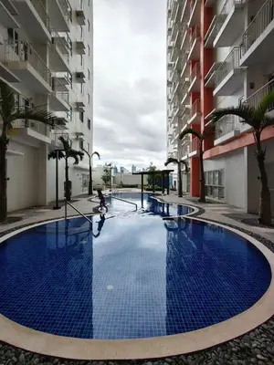 a large blue pool in the middle of a building at Quantum Residences in Manila