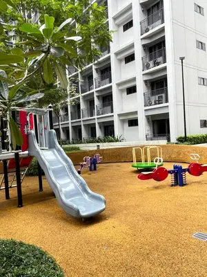 a playground with a slide in front of a building at Athara Suites 2 in Manila