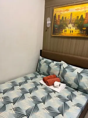 a bed with a tray and a plate on it at Athara Suites 2 in Manila