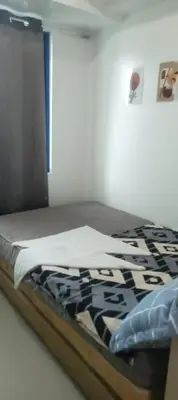 a bed with a black and white blanket on it at Sea Residence 2026 in Manila