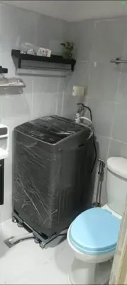 a small bathroom with a toilet and a tv at Sea Residence 2026 in Manila