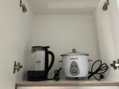 a coffee maker and a slow cooker on a shelf at 3Ms Homestay Shore in Manila