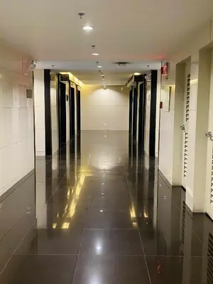 an empty hallway in a building with a tile floor at Stylish 1BR Air Residences Wifi & Netflix in Manila