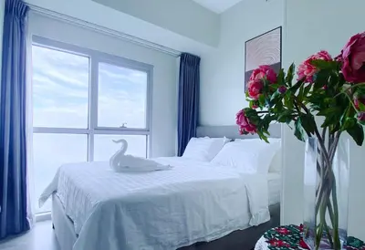 a bedroom with a white bed with a swan on it at 2BR Luxurious Ocean View, close Okada, Solaire, MOA, Airport with free parking in Manila