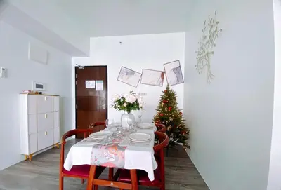 a dining room with a table with a christmas tree at 2BR Luxurious Ocean View, close Okada, Solaire, MOA, Airport with free parking in Manila