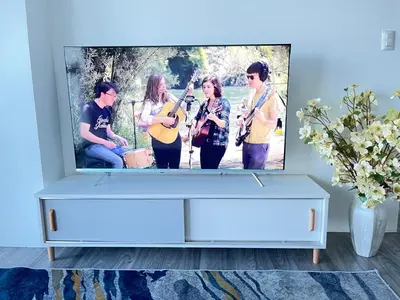 a living room with a tv showing a group of girls playing music at 2BR Luxurious Ocean View, close Okada, Solaire, MOA, Airport with free parking in Manila