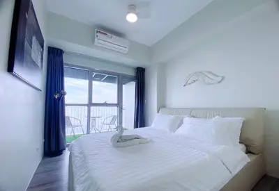 a bedroom with a white bed and a window at 2BR With Magnificent Bayview GARDEN View Near Okada, Solaire, Airports, Free Parking in Manila
