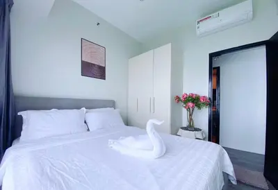 a white swan sitting on a bed in a bedroom at 2BR With Magnificent Bayview GARDEN View Near Okada, Solaire, Airports, Free Parking in Manila