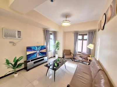 a living room with a couch and a tv at GOUTEI Homestay - The Radiance Manila Bay in Manila