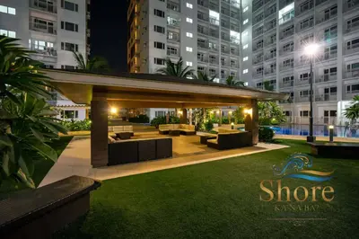 a patio with couches and tables in a city at night at Shore ka na ba in Manila