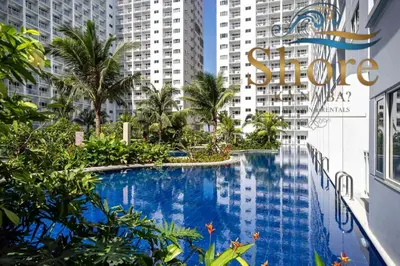 a swimming pool in the middle of a building with tall buildings at Shore ka na ba in Manila