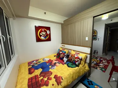 a bedroom with a superman bed with yellow bedspread at Wonder Collective Stays in Manila