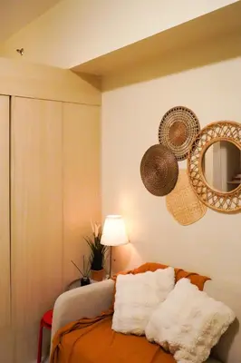 a bedroom with a bed with a mirror and baskets at SMDC LIGHT Balcony Smart TV Alexa Cozy Retreat in Manila