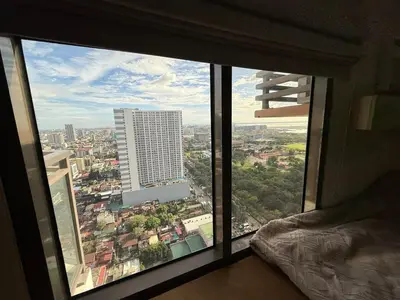 a view of a city from a large window at 2BR Near Manila Bay MOA l Airport with FREE use of Pool l 4 PPL in Manila