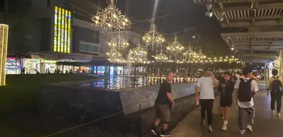 a group of people walking through a building with lights at BGC Forbes Area Your Home Away From Home in the Heart of BGC with hi-speed Wi-Fi PrimeVideo,Disney ,Netflix in Manila