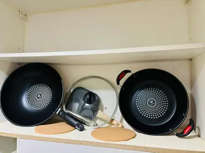 two pots and pans sitting on a shelf at Shore Balcony MOA Price worthy Wifi Pool Netflix in Manila