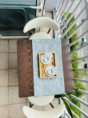 a table with two white chairs and a speaker at Shore Balcony MOA Price worthy Wifi Pool Netflix in Manila