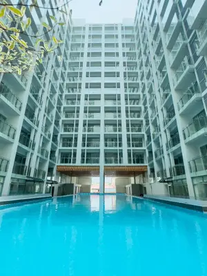 a large apartment building with a large swimming pool at Cozy Family Suite with City View near City of Dreams Casino, Airport, Solaire, Okada, Ayala Malls and MOA in Manila