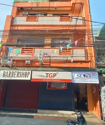 a store with a sign on the side of a building at SL Bedspace Transient House in Manila