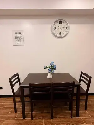 a table with chairs and a clock on the wall at Sy bay suites near PITX NAIA Airport T3 MOA Okada MSV2107 in Manila