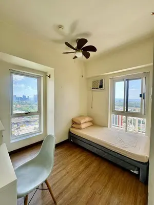 a bedroom with a bed and two windows at Vacation at Munti in Manila