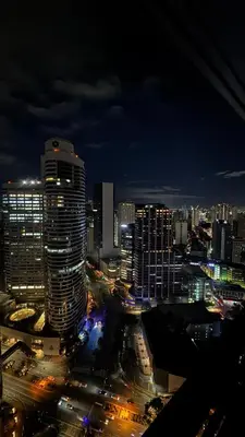 a city lit up at night with buildings and traffic at Snooze & Stay in Manila
