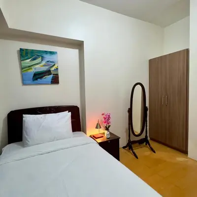 a bedroom with a white bed and a mirror at Entire 2BR apartment in BGC in Manila