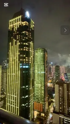 a tall building with lights on in a city at night at Entire 2BR apartment in BGC in Manila