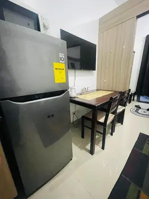 a kitchen with a table and a refrigerator in a room at H&M condotel in Manila
